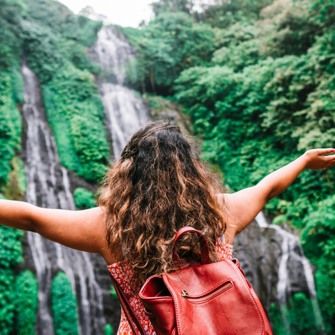Image of a woman in front of a waterfall