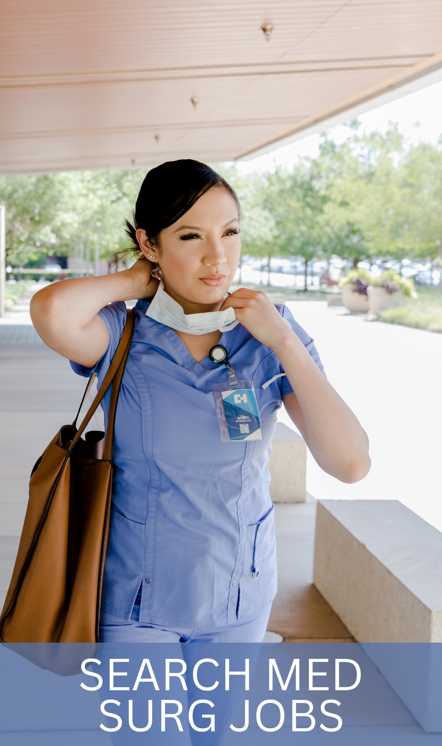 Medical-Surgical nurse in light blue scrubs assessing a patient's chart while standing in a hospital corridor, showcasing the attentive care Med-Surg specialists provide.