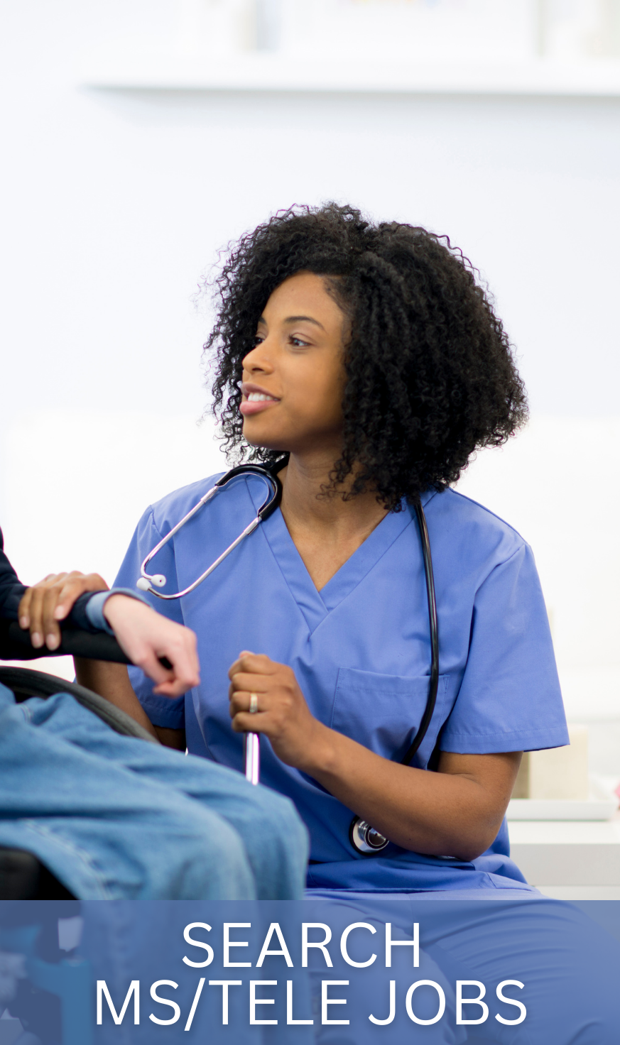 Telemetry nurse in light blue scrubs analyzing cardiac monitoring data at a nursing station, showing the specialized heart monitoring expertise these professionals provide.